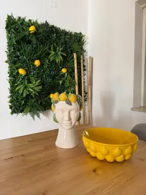 a vase sitting on a table with a yellow bowl at Lemon Beach House - São Rafael in Albufeira