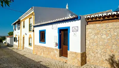 a white building with a brown door on a street at Perfect To Relax in Algoz