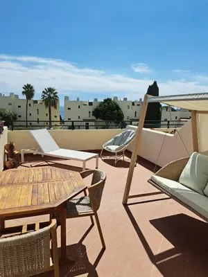 a patio with chairs and a table on a roof at White Studio and Terrace in Albufeira