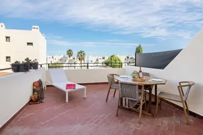 a patio with a table and chairs on a balcony at White Studio and Terrace in Albufeira