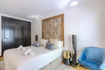 a bedroom with a white bed and a blue chair at #335 Recanto do Manaca by Home Holidays in Guia