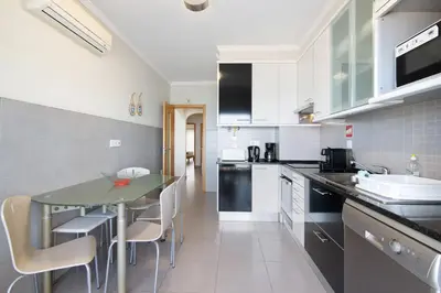 a living room with a chair and a table at Quarteira Modern Flat in Quarteira