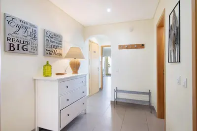 a room with a lamp on a counter and a hallway at Quarteira Modern Flat in Quarteira