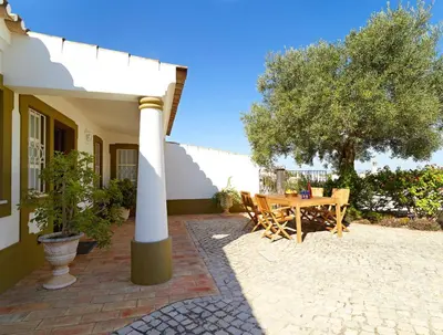 a patio with a wooden table and a tree at Oliveira by Vintage Travel in Guia