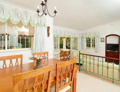 a dining room with a table and chairs and windows at Oliveira by Vintage Travel in Guia