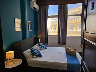 a small bed in a room with a window at Blife Portugalya - private rooms at Santantonya 2nd floor in Faro