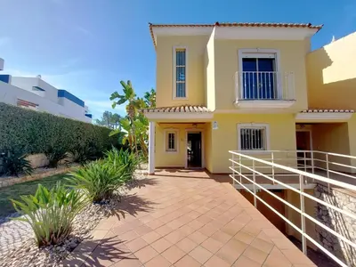 a yellow house with a pathway in front of it at Vilapeti by SAPvillas in Quarteira