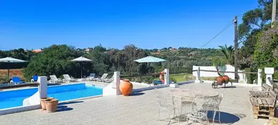 a swimming pool with chairs and a table and a table and chairs at Quinta do Lagar - 01 in Albufeira