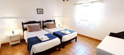 two twin beds in a room with a window at Quinta do Lagar - 02 in Albufeira