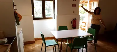 a woman standing in a room with a table and chairs at Quinta do Lagar - 02 in Albufeira