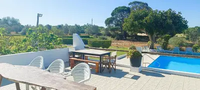 a patio with a table and chairs and a pool at Quinta do Lagar - 03 in Albufeira
