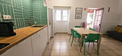 a kitchen with a table and green and white wallpaper at Quinta do Lagar - 04 in Albufeira