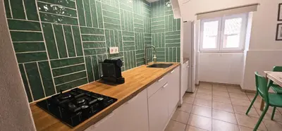 a kitchen with green tiled walls and a stove and sink at Quinta do Lagar - 04 in Albufeira