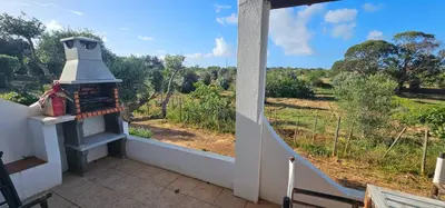a balcony with a fireplace with a view of a field at Quinta do Lagar - 05 in Albufeira