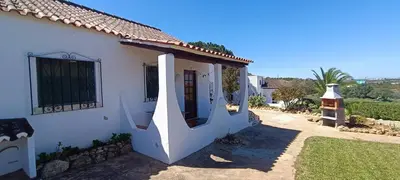 a white house with a door in a yard at Quinta do Lagar - 07 in Albufeira