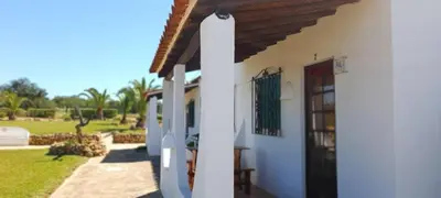 a white house with a door and a yard at Quinta do Lagar - 07 in Albufeira
