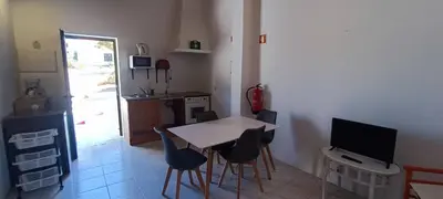 a kitchen with a table and chairs and a television at Quinta do Lagar - 09 in Albufeira
