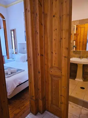 a room with a bed and a bathroom with a sink at The Central Faro in Faro