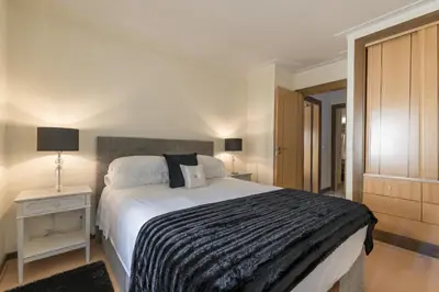 a bedroom with a large bed with a black and white blanket at V4 Duplex Quinta do Lago Sal in Quinta do Lago