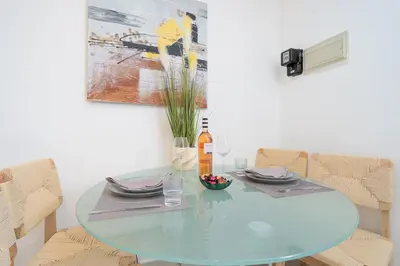 a glass table in a dining room with chairs at Casa Biamar in Albufeira