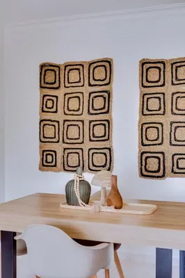 a dining room table with a white chair and two pictures at Brisa Algarvia 2 in Faro