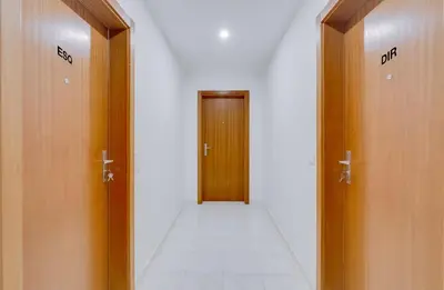 a hallway with two brown doors and a white tile floor at Brisa Algarvia 2 in Faro