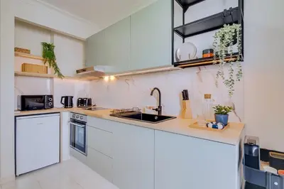 a kitchen with white cabinets and a sink at Brisa Algarvia 2 in Faro