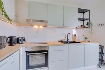 a kitchen with white cabinets and a sink at Brisa Algarvia 2 in Faro