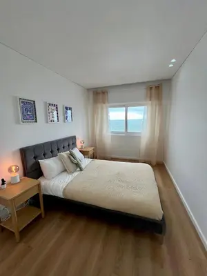 a bedroom with a large bed and a window at Ocean View Apartment Steps to Beach Vil15m Faro25m in Quarteira