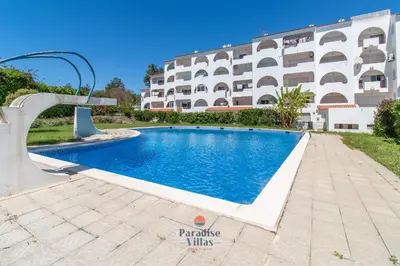 a view of the ocean between two rocky cliffs at Cozy 1-Bedroom Apartment, Pool, Central Albufeira in Albufeira