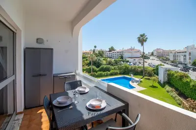 a living room with a couch and a flat screen tv at Cozy 1-Bedroom Apartment, Pool, Central Albufeira in Albufeira