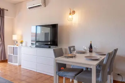 a kitchen with white cabinets and a stove top oven at Cozy 1-Bedroom Apartment, Pool, Central Albufeira in Albufeira