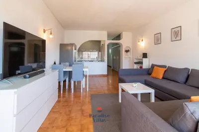 a small white bedroom with a bed and a desk at Cozy 1-Bedroom Apartment, Pool, Central Albufeira in Albufeira