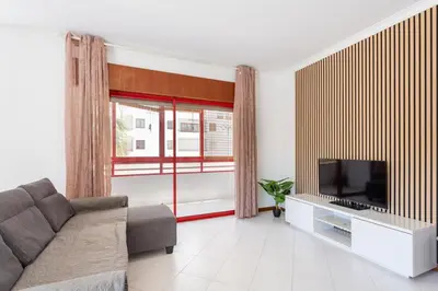 a living room with a couch and a television at SunnyQuarters WalktoBeach 2BR AC