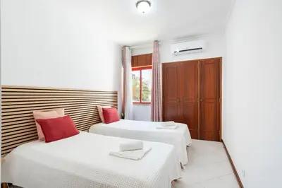 two beds in a room with white and red pillows at SunnyQuarters WalktoBeach 2BR AC