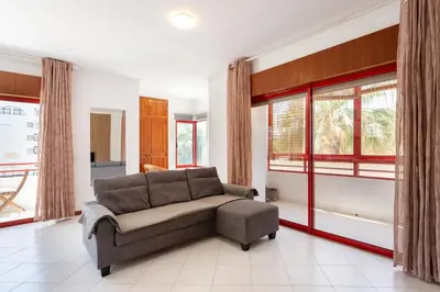 a living room with a couch and windows at SunnyQuarters WalktoBeach 2BR AC