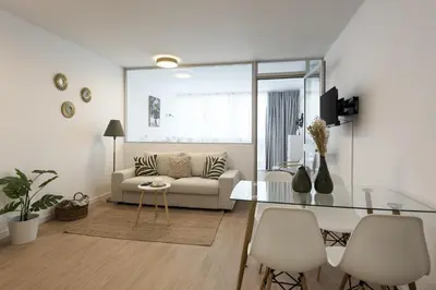 a living room with a couch and a glass table at Maya Vilamoura - City center by HD PROPERTIES in Vilamoura