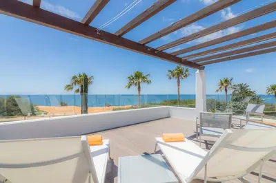 a patio with chairs and an umbrella next to a pool at Golf&Mar By Garvetur Villas in Loulé