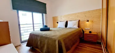 a bedroom with a bed with a large window at Fantástico T2 Perto da Praia da Falésia, Albufeira in Albufeira