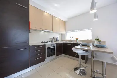 a kitchen with brown cabinets and a white counter top at Casa A in Olhos de Água