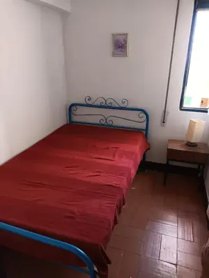 a bed in a room with a red blanket on it at Apartamento Alto de Abufeira in Albufeira