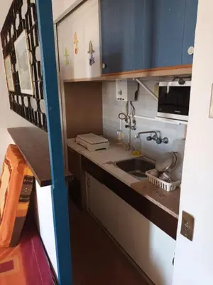 a small kitchen with a sink and blue cabinets at Apartamento Alto de Abufeira in Albufeira