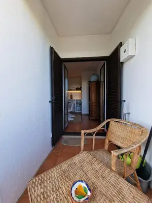 a living room with a chair and a table at Incrível T1 na praia da Oura in Albufeira