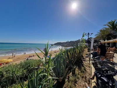 a beach with people on the sand and the ocean at Incrível T1 na praia da Oura in Albufeira