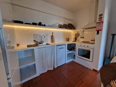 a kitchen with white counters and a sink at Incrível T1 na praia da Oura in Albufeira