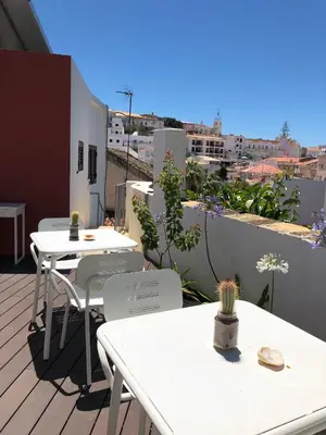 a balcony with tables and chairs on a roof at Casa Malpique in Albufeira