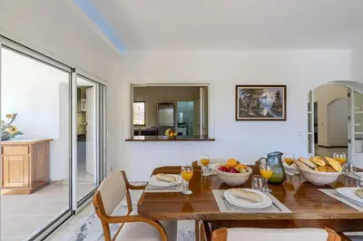 a dining room and living room with a table and chairs at #336 Vila Sol by Home Holidays in Sesmarias