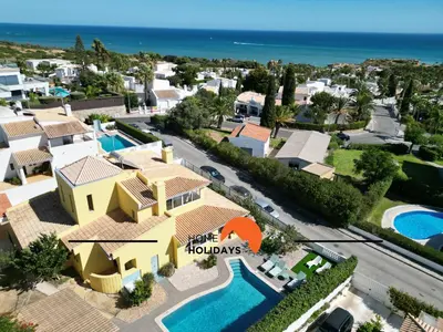 a white bedroom with a large bed and a desk at #336 Vila Sol by Home Holidays in Sesmarias