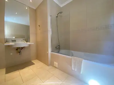 a bathroom with a shower and a tub and a sink at Villa 