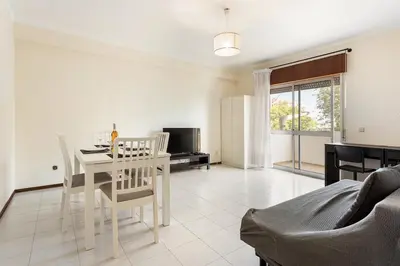 a living room with a white table and chairs at Amoreira 3br City Center at Homesbyfc in Faro